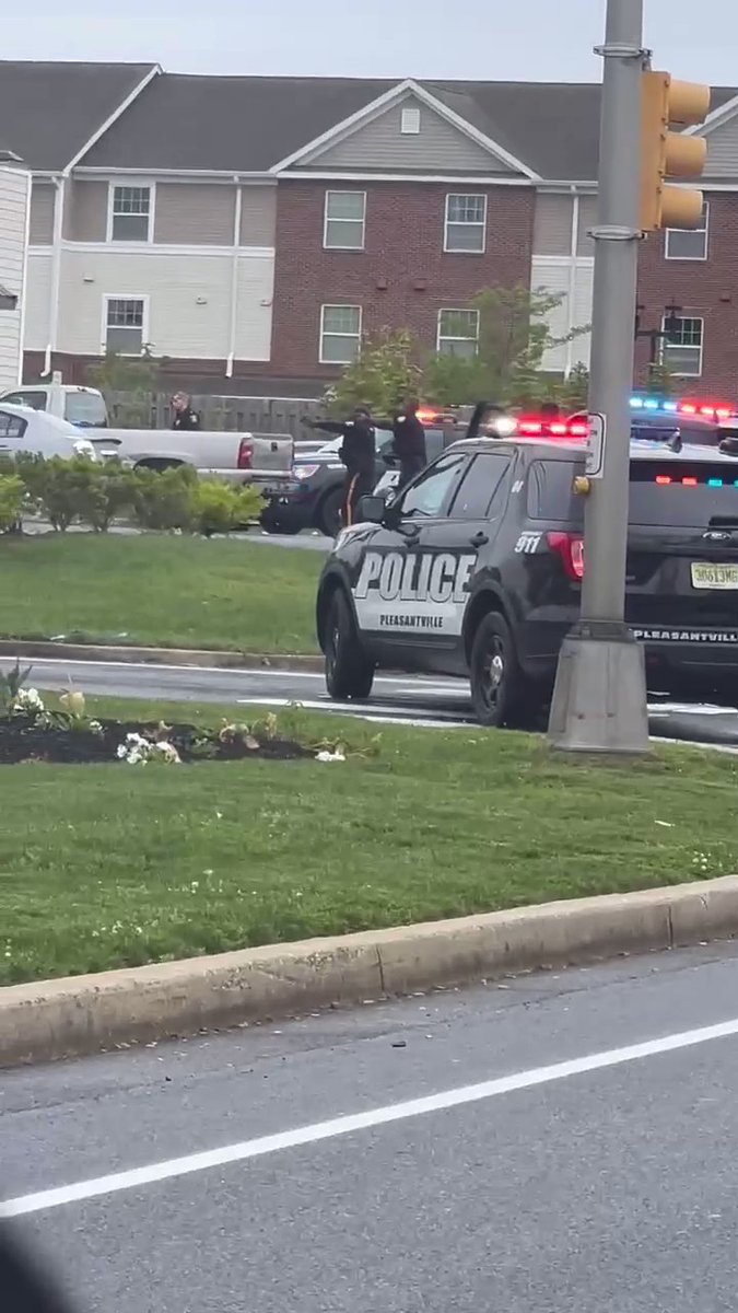 Officers surround a light-colored pickup truck with their guns drawn outside the Dollar General in Pleasantville, Atlantic County.