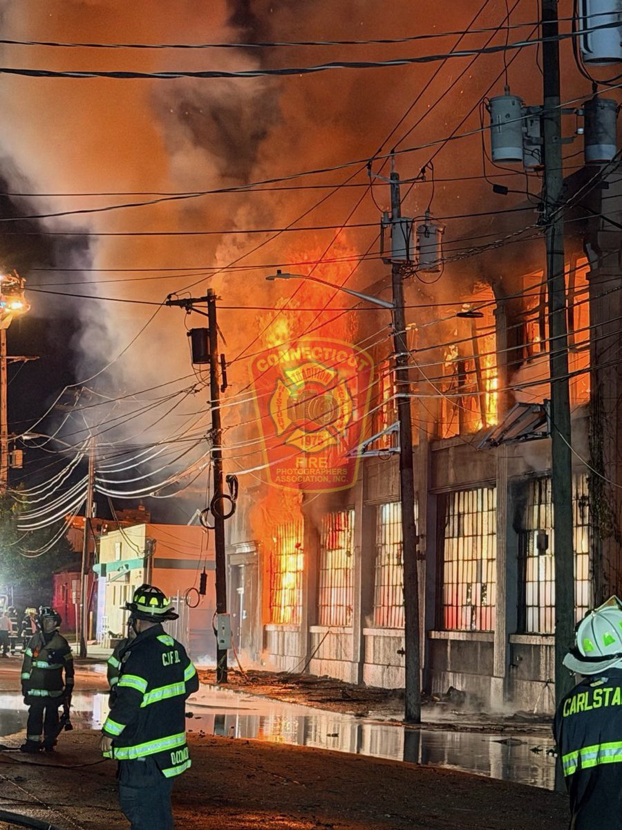 CFPA Vice President Chris Clarke (@FirstDuePhotog) reports the 9 Alarm blaze continues to burn as crews are dealing with water supply issues